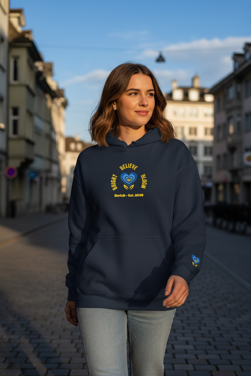 Woman wearing a navy blue hoodie with a logo and text, standing on a street with buildings in the background.